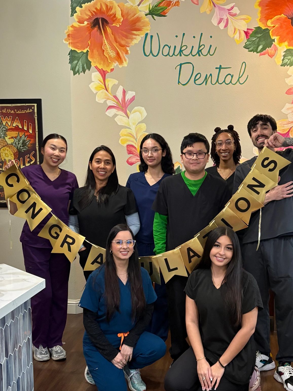 Roseville Dental Academy students celebrating in scrubs inside Waikiki Dental.