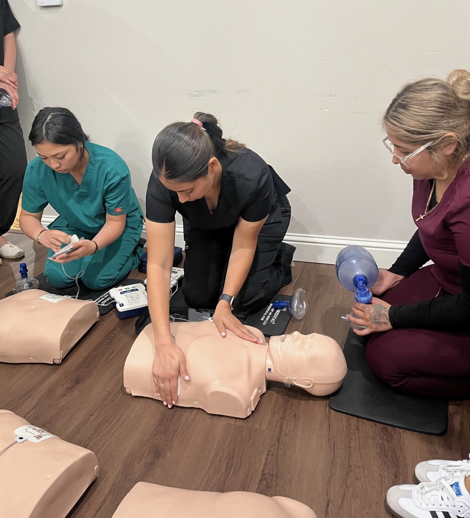 Roseville Dental Academy students practicing BLS CPR skills on training manikins.